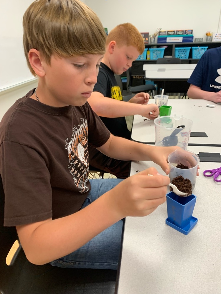 Bayne Strick and Kyson Messer planting their herbs in 6th grade science.